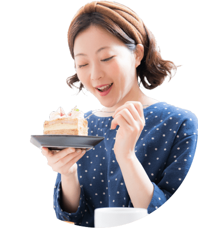 笑顔でケーキを食べている女性の写真